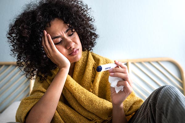 ill woman with thermometer