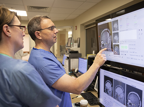 Zachary Levine, MD, medical director, neurosurgery and neuroscience, Holy Cross Health, reviews MRI images during a Visualase laser ablation procedure_Visualase.jpg