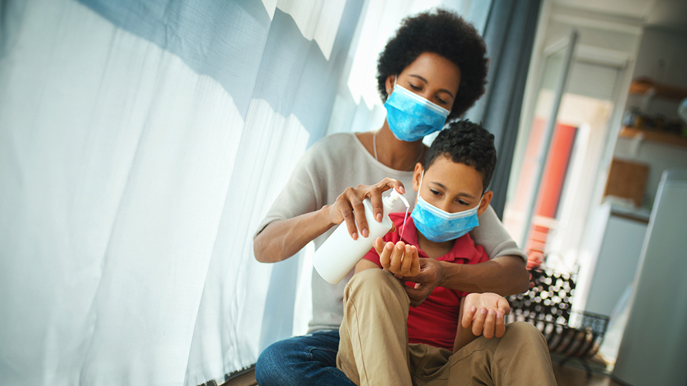 woman and son sanitizing hands